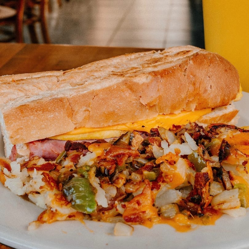 Mamas Kitchen's breakfast sandwich with ham, egg, and cheese, served with a side of home fries.